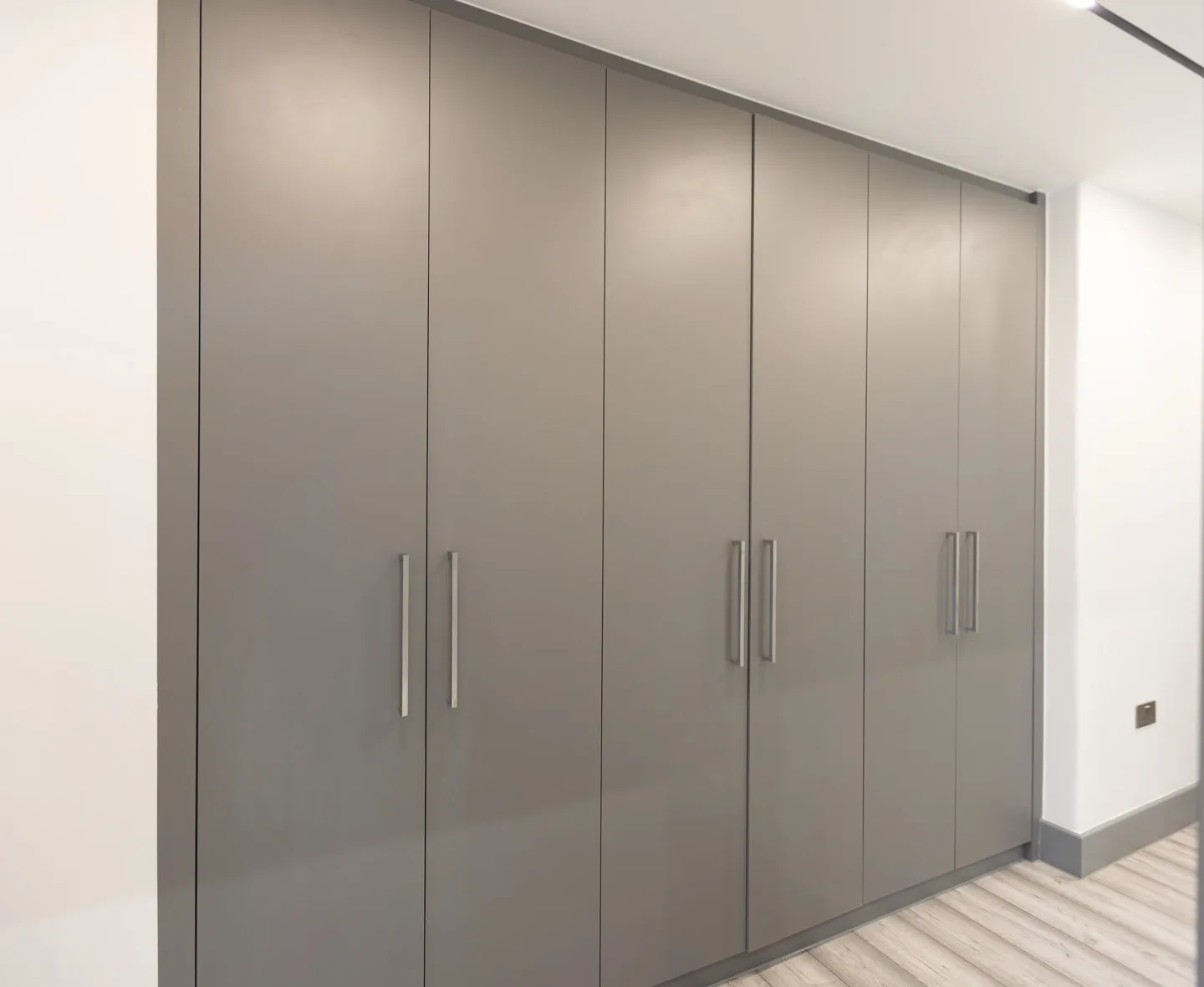 Bespoke fitted wardrobe grey doors brushed chrome handles — Kensington