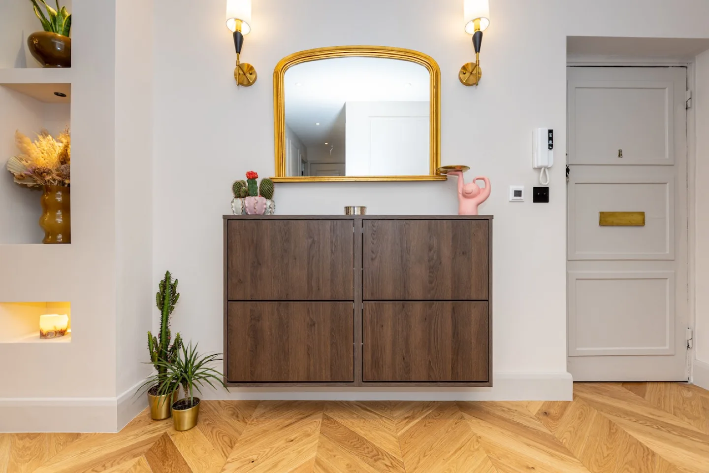 Bespoke wall-mounted dark oak shoe cabinet in the hallway, with a gold mirror and wall lights above