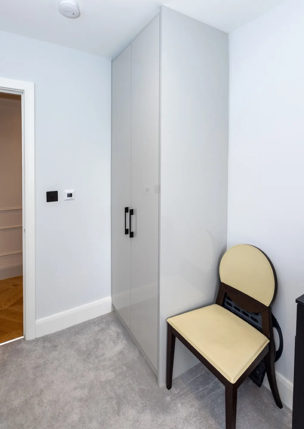 Freestanding cream gloss wardrobe with black bar handle in the second guest bedroom