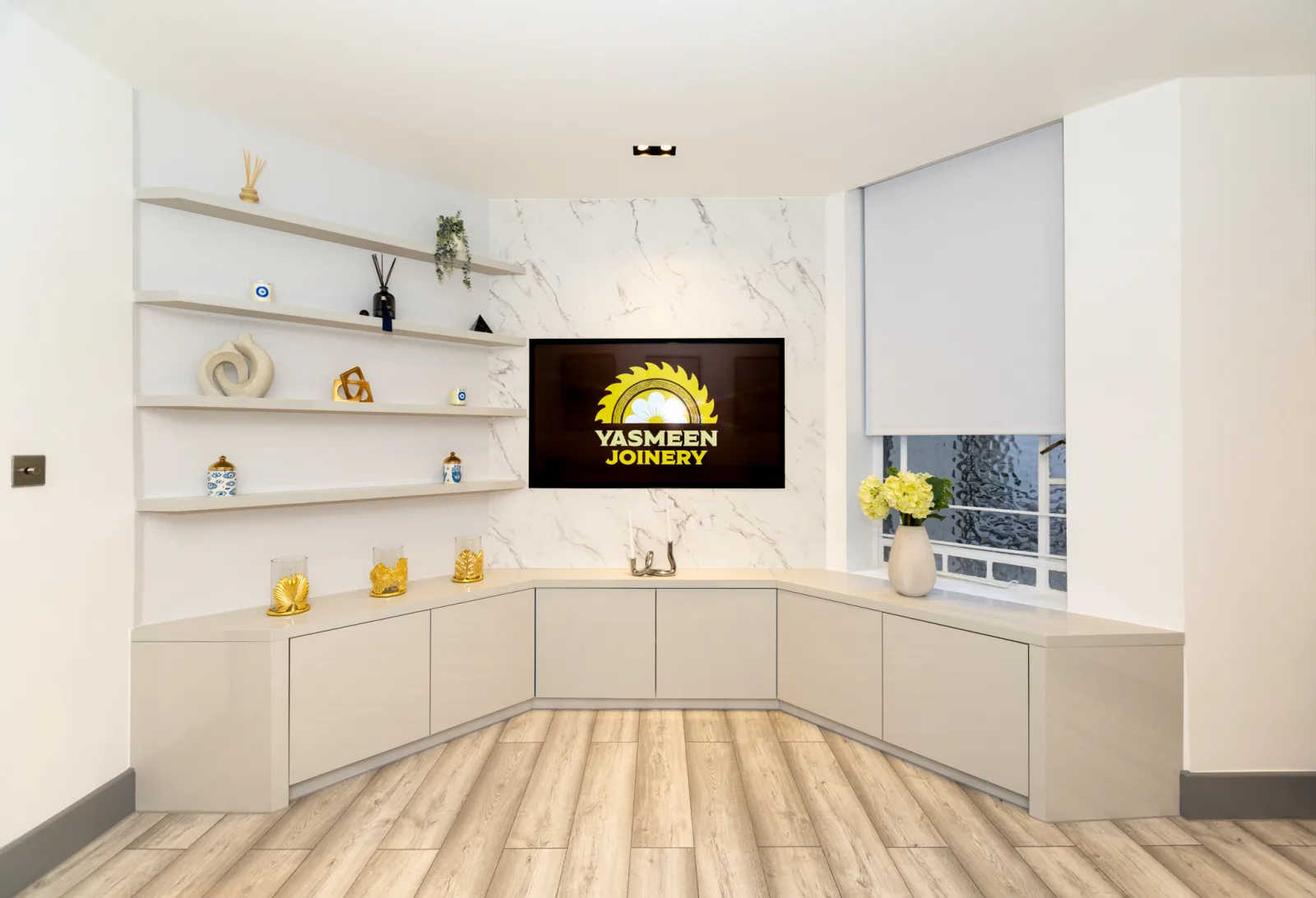 Bespoke corner media unit with a marble feature wall and integrated TV in a Kensington home