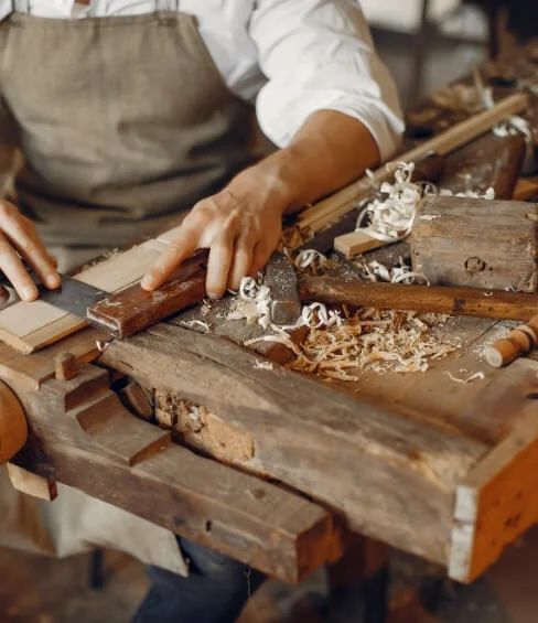Wooden craftsman working with a plank.