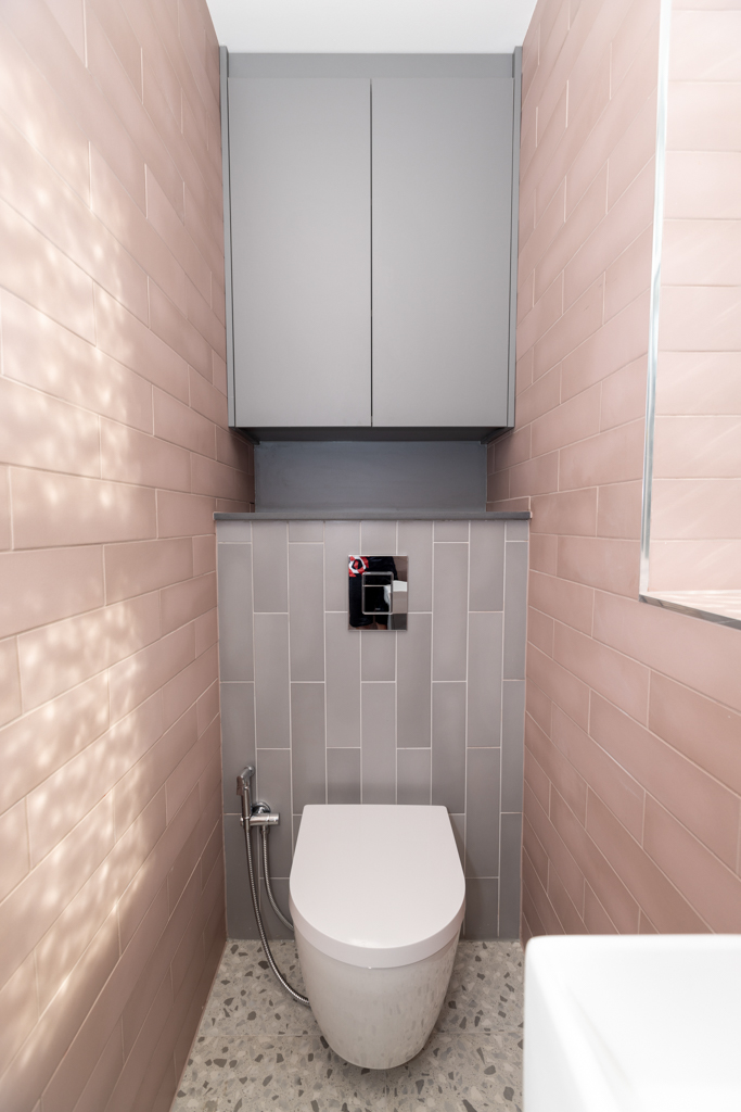 white porcelain toilet and pink tile wall.