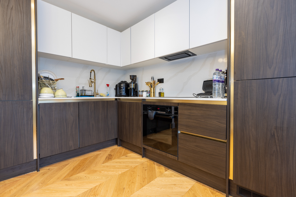 dark brown and gold kitchen with wooden floors.