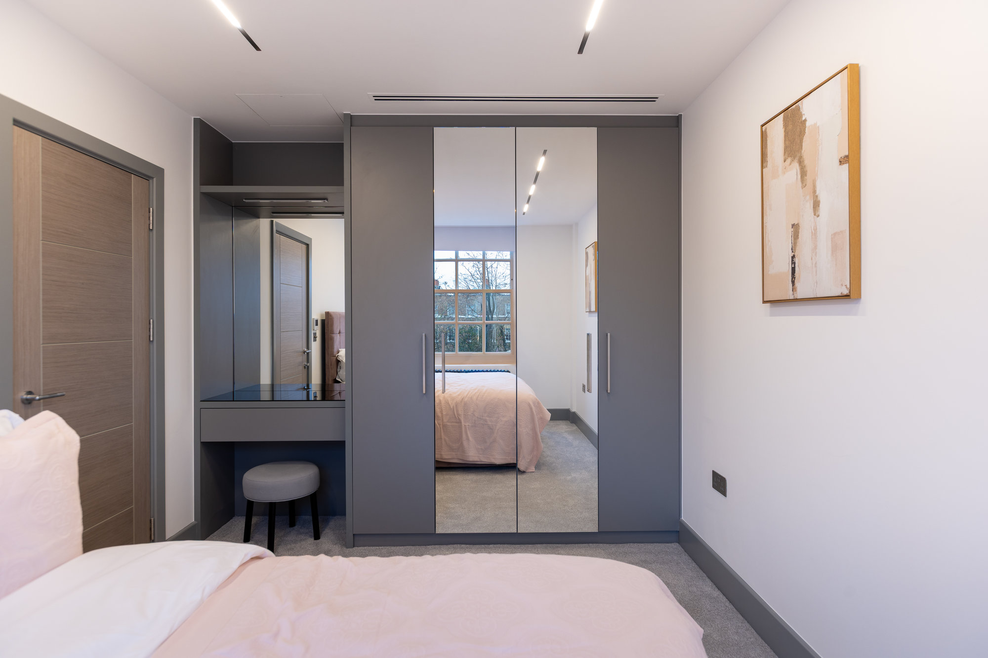 Bespoke wardrobe with built-in desk open showing LED-lit interior with soft-close drawers and hanging rails in Kensington
