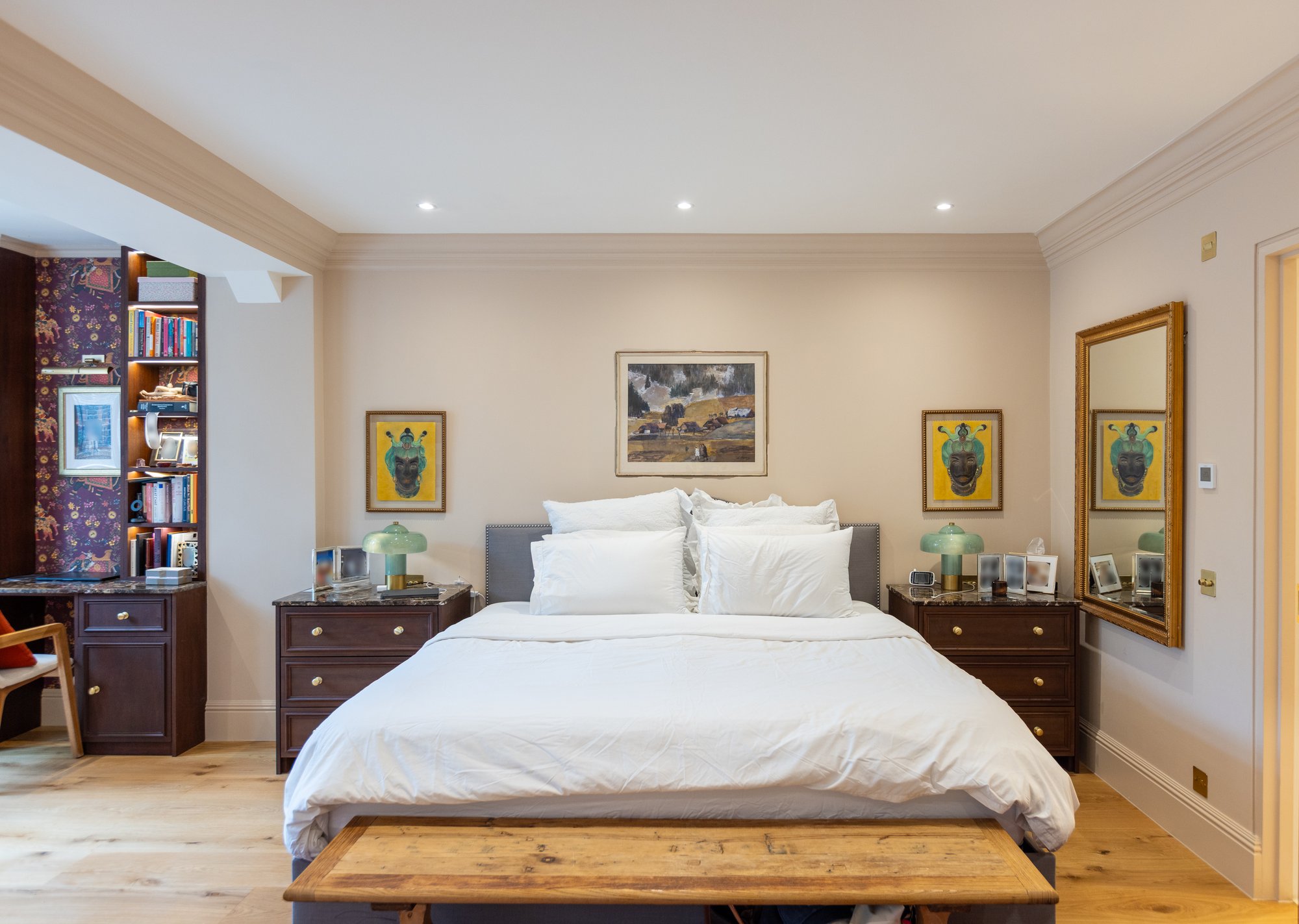 Full bedroom view of a Kensington home showing bespoke dark oak joinery including built-in desk with bookshelves, matching bedside drawers, and upholstered bed